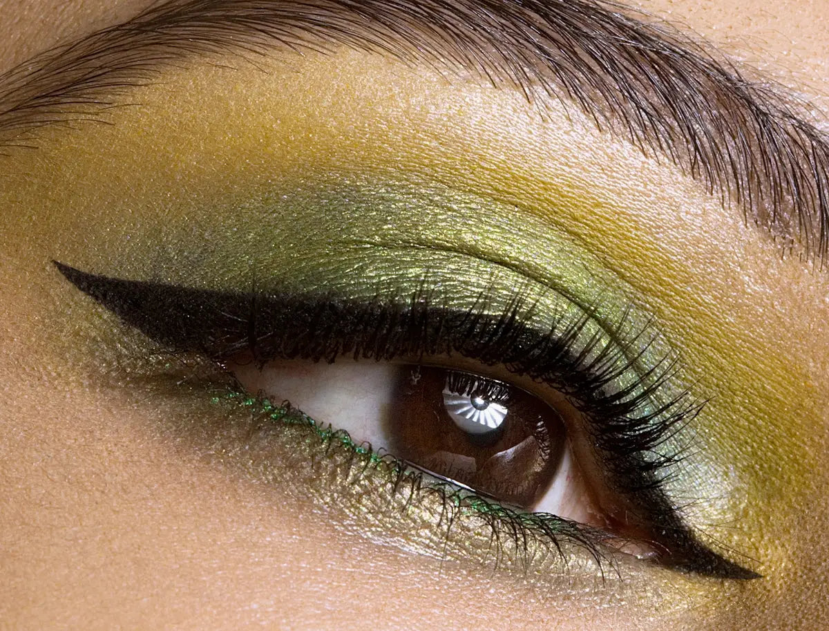 a woman's eye with green and yellow makeup