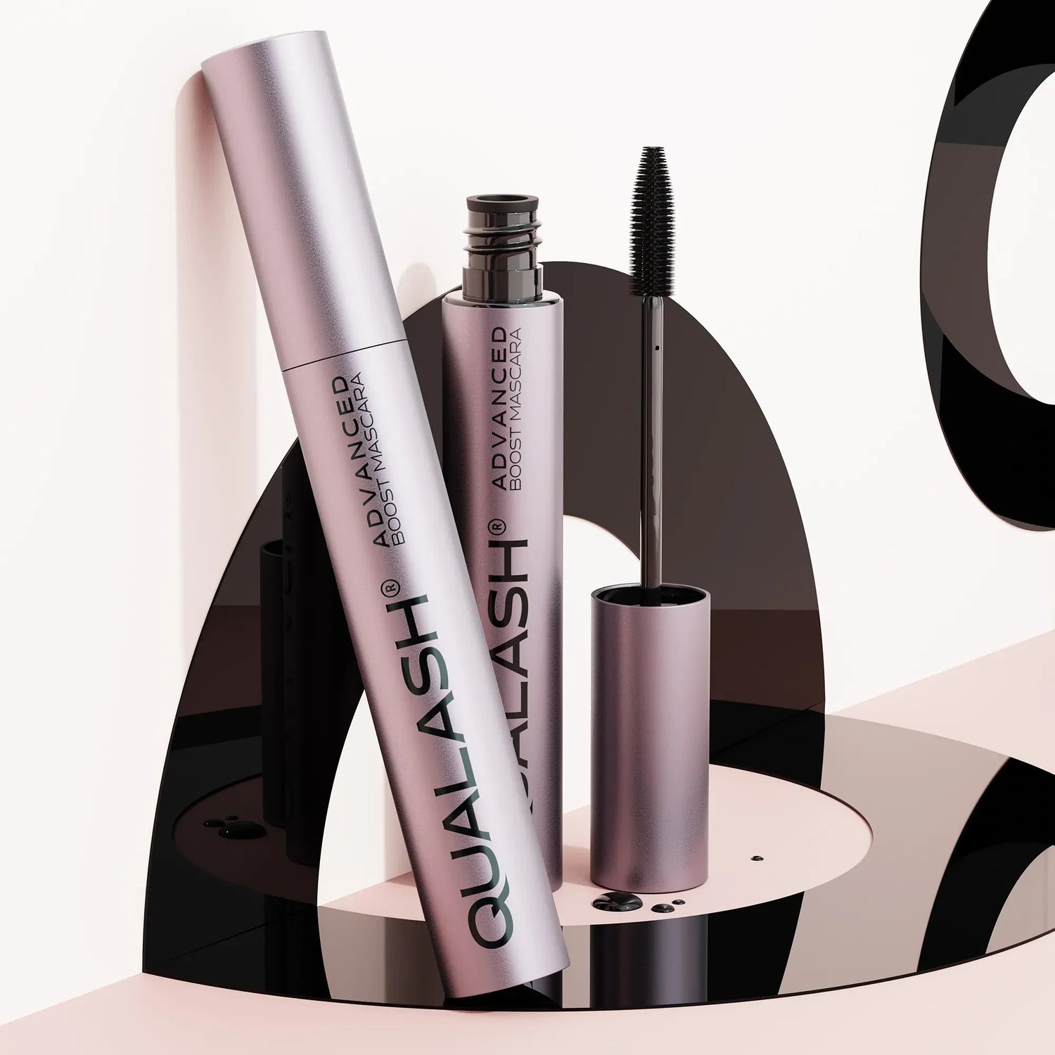 QUALASH Advanced Boost Mascara set displayed on modern artistic black and pink setup